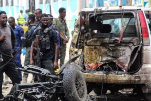 सोमालिया के मोगादिशु में शनिवार को एक कार बम हमले की साइट पर सुरक्षा अधिकारी गश्त करते हैं।  (छवि: स्ट्रिंगर/एएफपी)