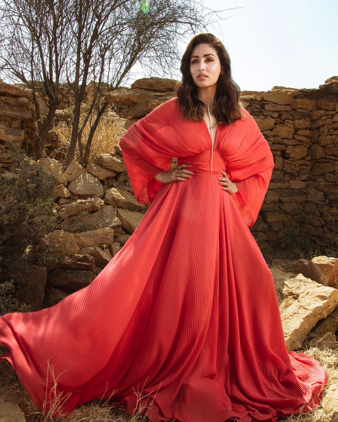 Yami Gautam cuts a striking figure in the red flowing gown.