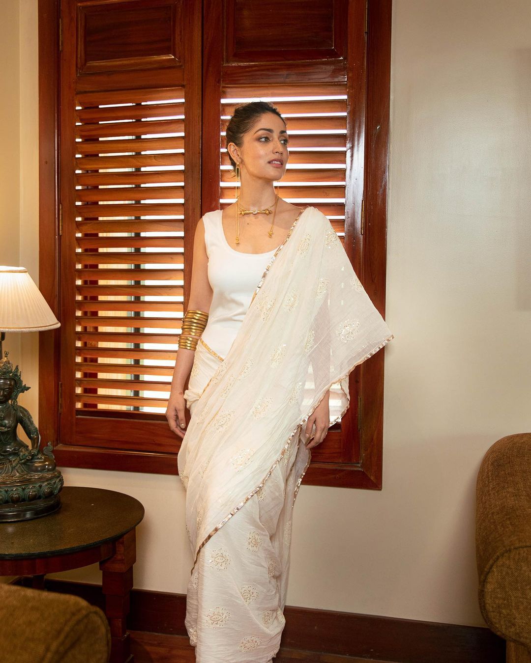 Yami Gautam accessorised her white saree with gold jewellery.