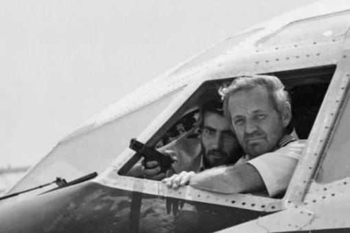 American pilot John Testrake taken hostage by an armed man on June 19, 1985 on the tarmac of Beirut International Airport. (Credit: Nabil Ismail/AFP)