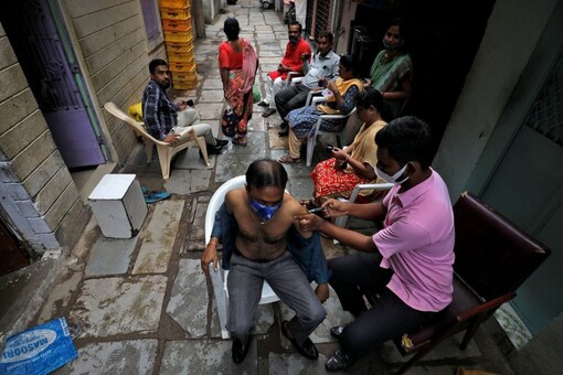 A man receives a dose of the COVISHIELD vaccine, in an alley at a slum area.(REUTERS/Amit Dave)
