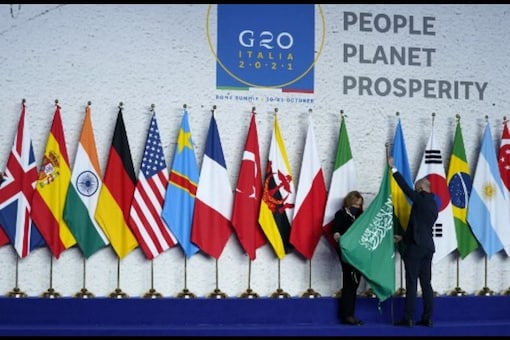 In this file photo, employees arrange flags before world leaders gather for the official photograph on day 1 of the G20 Summit in Rome. (Image: Evan Vucci/POOL/AFP)