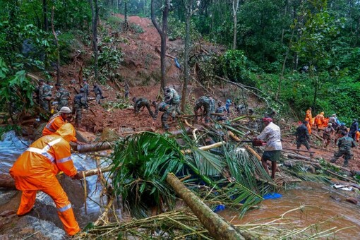 Rescuers search for bodies of victims amist the debris of a landslide following heavy rains at Koottickal in Kottayam district, southern Kerala. (AP)