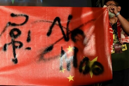 Demonstrators hold the national flag of China upsidedown with writtings over it during an anti-China rally outside the parliament in Taipei on October 1, 2021.Sam Yeh / AFP