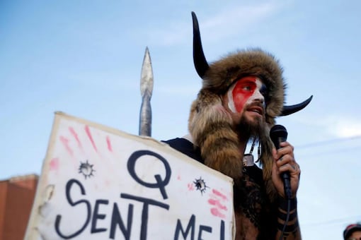 Jacob Chansley, holding a sign referencing QAnon, speaks as supporters of U.S. President Donald Trump gather to protest about the early results of the 2020 presidential election. (Reuters)