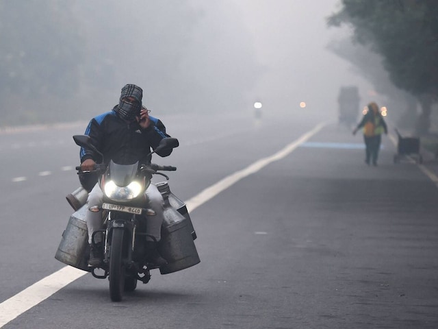 Vehicles ply on a road amid heavy fog in the morning.(PTI)