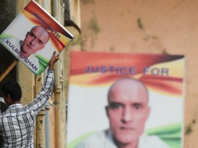 A man holds a placard depicting Kulbhushan Jadhav in Mumbai on July 17, 2019. (AFP)