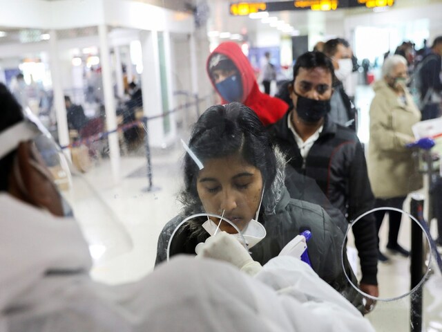A healthcare worker collects a coronavirus disease (COVID-19) test swab sample from a woman at the Indira Gandhi International Airport in New Delhi. (File photo: PTI)
