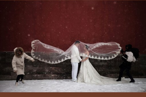 A couple poses for a wedding photo shoot amid snowfall at the Imperial Ancestral Temple in Beijing. (Image: Reuters)