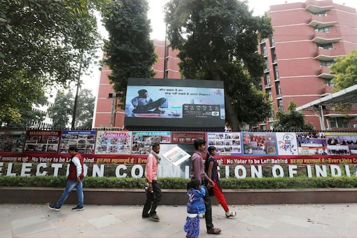 People walk past the Election Commission of India office building in New Delhi, India March 11, 2019. REUTERS/Adnan Abidi