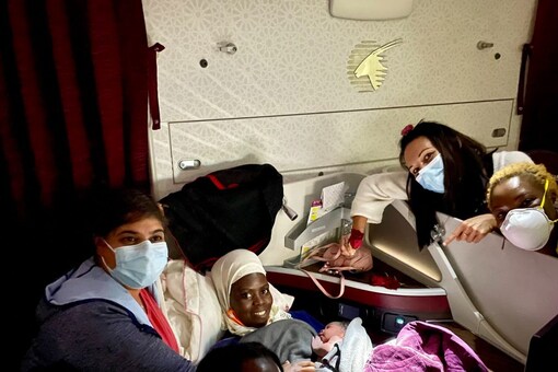 Dr Khatib  (top left) seen with the mother and Miracle Aisha aboard the Qatar Airways flight. (Image: @AishaKhatib/Twitter)