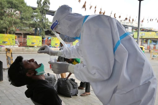 A health worker collects the nasal swab sample of a traveler to test for Covid-19 outside a bus terminal in Bengaluru, on January 8, 2022. (AP Photo/Aijaz Rahi)