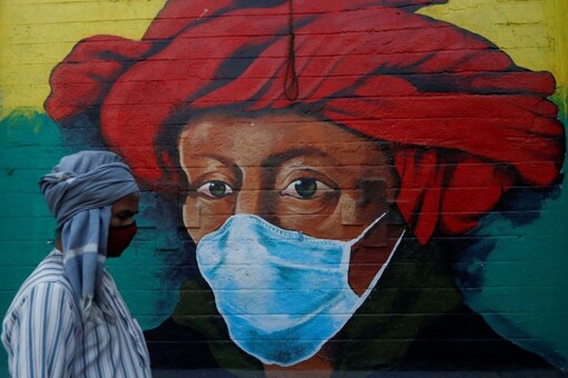 A man walks past a mural on a street, amidst the spread of the coronavirus disease (COVID-19), in Mumbai, India, January 10, 2022. REUTERS/Francis Mascarenhas