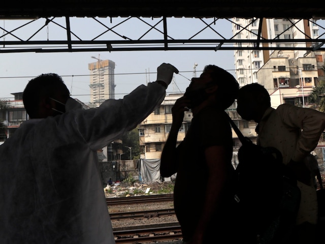A health worker collects a swab sample from a traveller at a railway station to test for Covid-19. (File photo/AP)