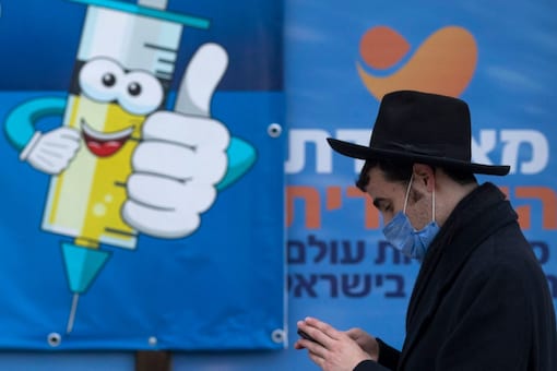 An Ultra-Orthodox Jewish man walks past a coronavirus vaccination center, in Jerusalem. (AP)