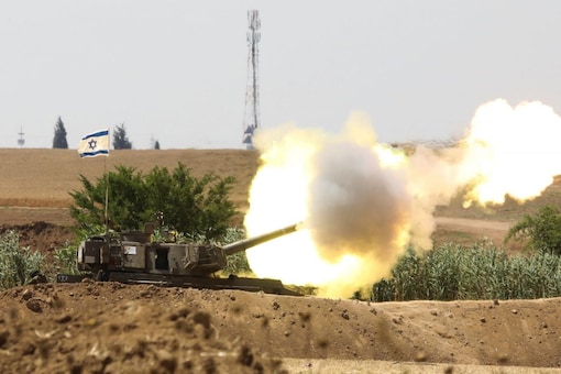 For File: An Israeli flag flutters near an artillery unit as it fires near the border between Israel and the Gaza Strip, on the Israeli side May 20, 2021. REUTERS/Baz Ratner
