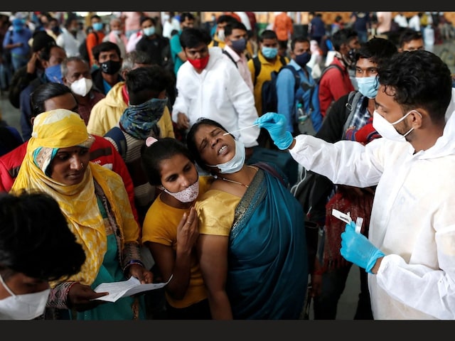 A woman reacts as a health worker collects a swab sample during a rapid antigen testing campaign for Covid-19 at a railway station in Mumbai on January 13. (File photo/Reuters)