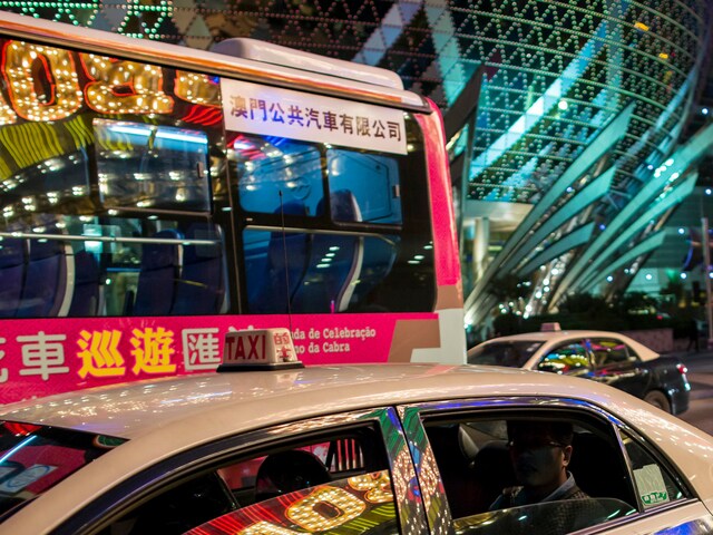 A taxi in which the Casino Lisboa is reflected stops in front of the Grand Lisboa (in background), in Macau February 17, 2015. These two are the major casinos of SJM Holdings founded by Macau tycoon Stanley Ho. (Credits: Reuters)