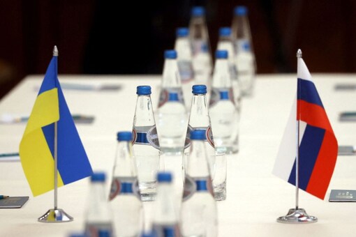 Russian and Ukrainian flags are seen on a table before the first round of talks between officials of the two countries in the Gomel region, Belarus February 28, 2022. (Reuters)