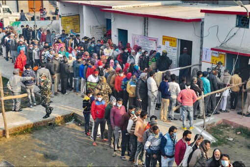 Voters wait to cast their ballots at a polling booth during the second phase of Uttar Pradesh Assembly elections, in Moradabad on February 14, 2022. (PTI Photo)