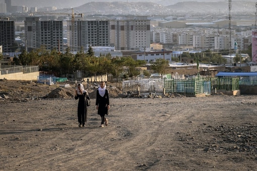 Two girls walk home through the Qasaba district on the outskirts of Kabul (Image and Caption: NYT/Jim Huylebroek)
