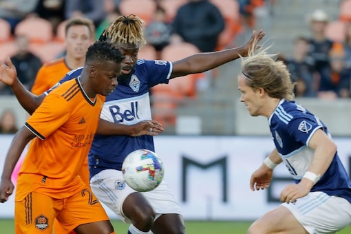 Houston Dynamo forward Carlos Darwin Quintero, left, tries to move the ball past Vancouver Whitecaps midfielders Leonard Owusu, middle, and Florian Jungwirth, right, during the first half of an MLS soccer match Saturday, March 12, 2022, in Houston. (AP Photo/Michael Wyke)