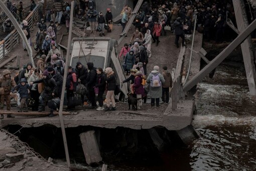 People cross a destroyed bridge as they try to leave the city of Irpin in the Kyiv region in Ukraine on March 5. (Image: Reuters)
