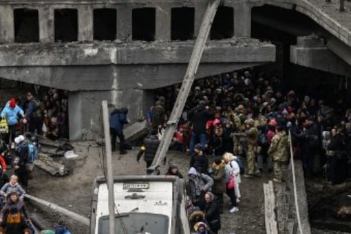 People cross a destroyed bridge as they evacuate Irpin city, northwest of Kyiv, during heavy shelling and bombing on March 5, 10 days after Russia launched a military in vasion on Ukraine. (Image: AFP)
