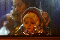 A child looks out of a window of a bus after crossing the border from Ukraine to Poland with people fleeing the Russian invasion of Ukraine, at the border checkpoint in Medyka, Poland, March 7, 2022. REUTERS/Fabrizio Bensch