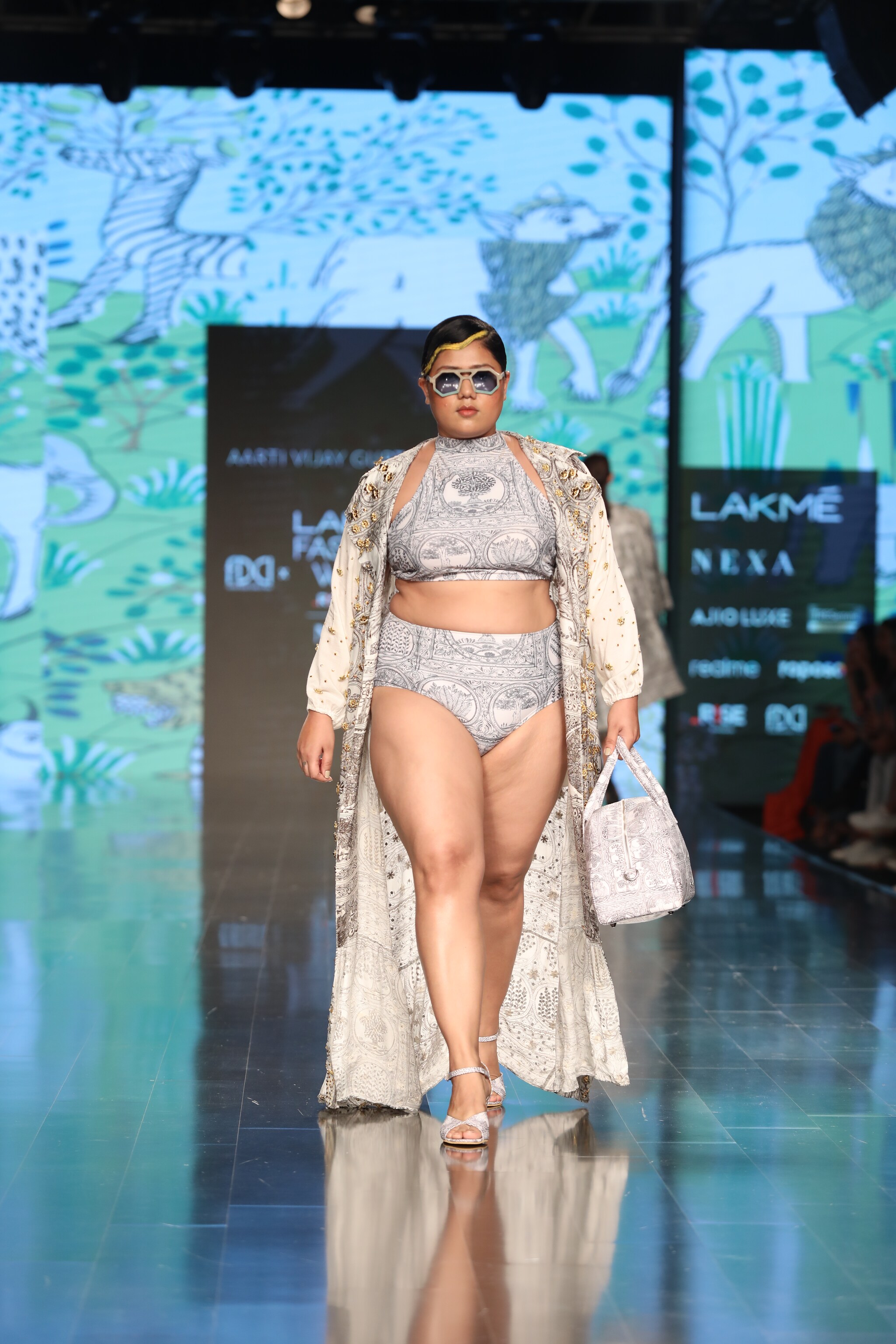 A model in a grey bikini set with an oversized jacket designed by fashion designer Aartivijay Gupta