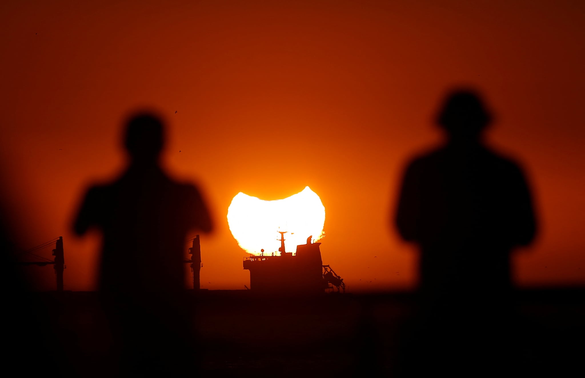 A partial solar eclipse is pictured during sunset in Vina del Mar, Chile on April 30. (Image: Reuters)