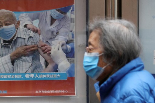 A person walks past a poster encouraging elderly people to get vaccinated against COVID-19 near a residential compound in Beijing, China (Image: Reuters/ Representative Image)