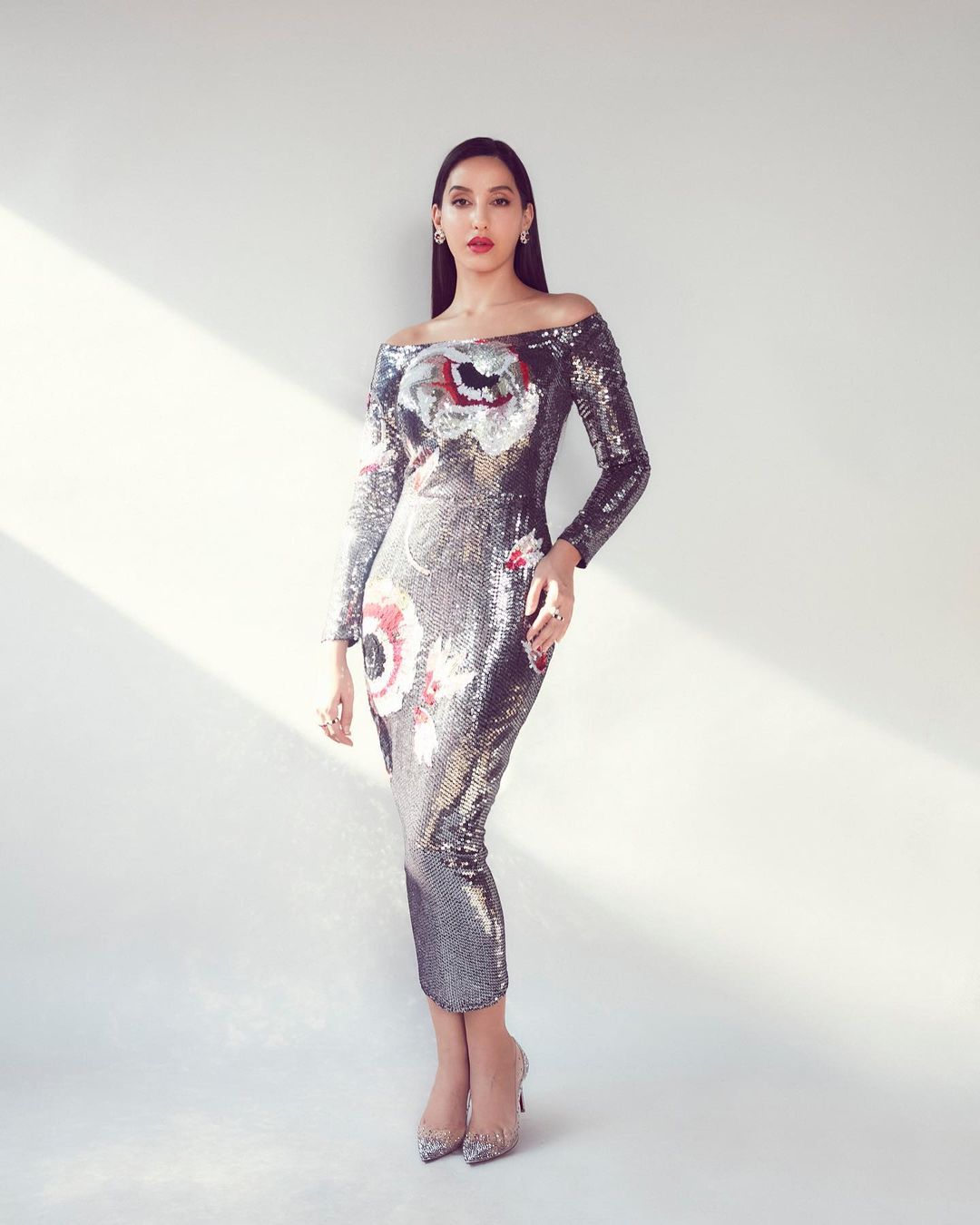 Nora Fatehi flaunts her curves in the silver shimmery dress.