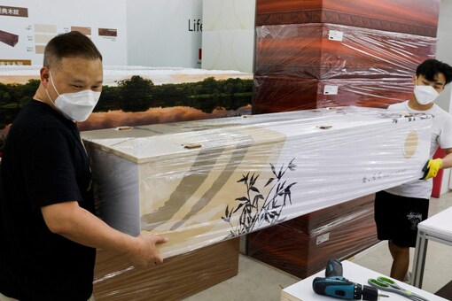 Workers carry an eco-friendly coffin at the factory of LifeArt during the coronavirus disease (COVID-19) pandemic, in Hong Kong, China (Image: Reuters)