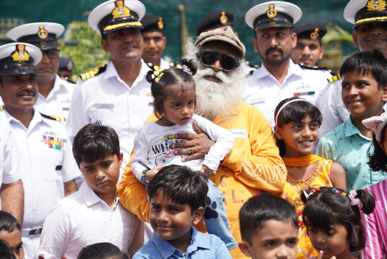 A lively youth crowd with Indian Navy personnel posing for a picture with Sadhguru after his arrival in India.  (Image credit: Isha Foundation) 