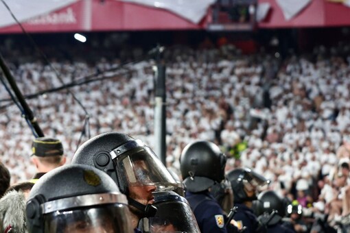 FILE - Riot police guard fans after the Europa League final soccer match between Eintracht Frankfurt and Rangers FC at the Ramon Sanchez Pizjuan stadium in Seville, Spain, Thursday, May 19, 2022 (AP Photo)