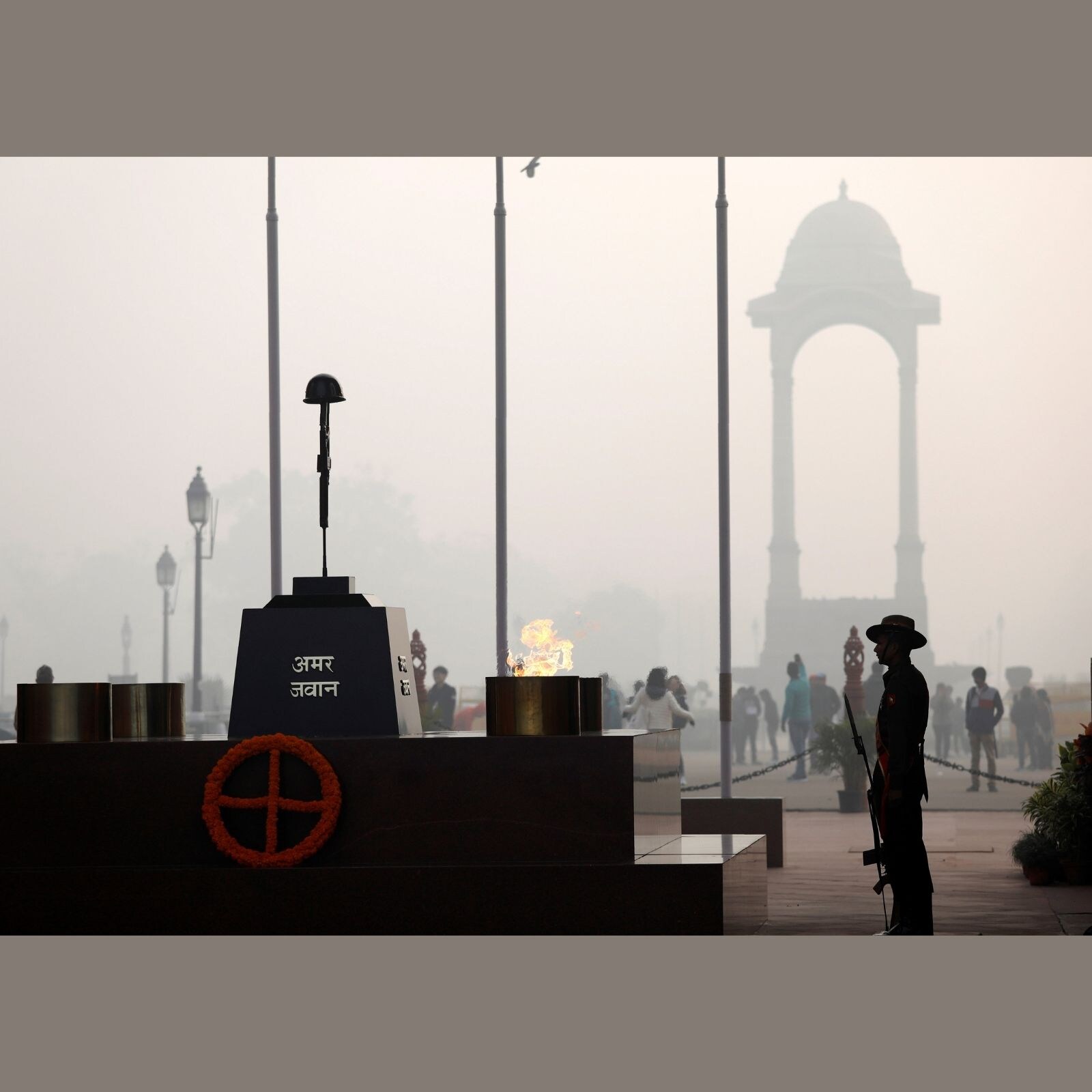 An army soldiers standing under the India Gate war memorial