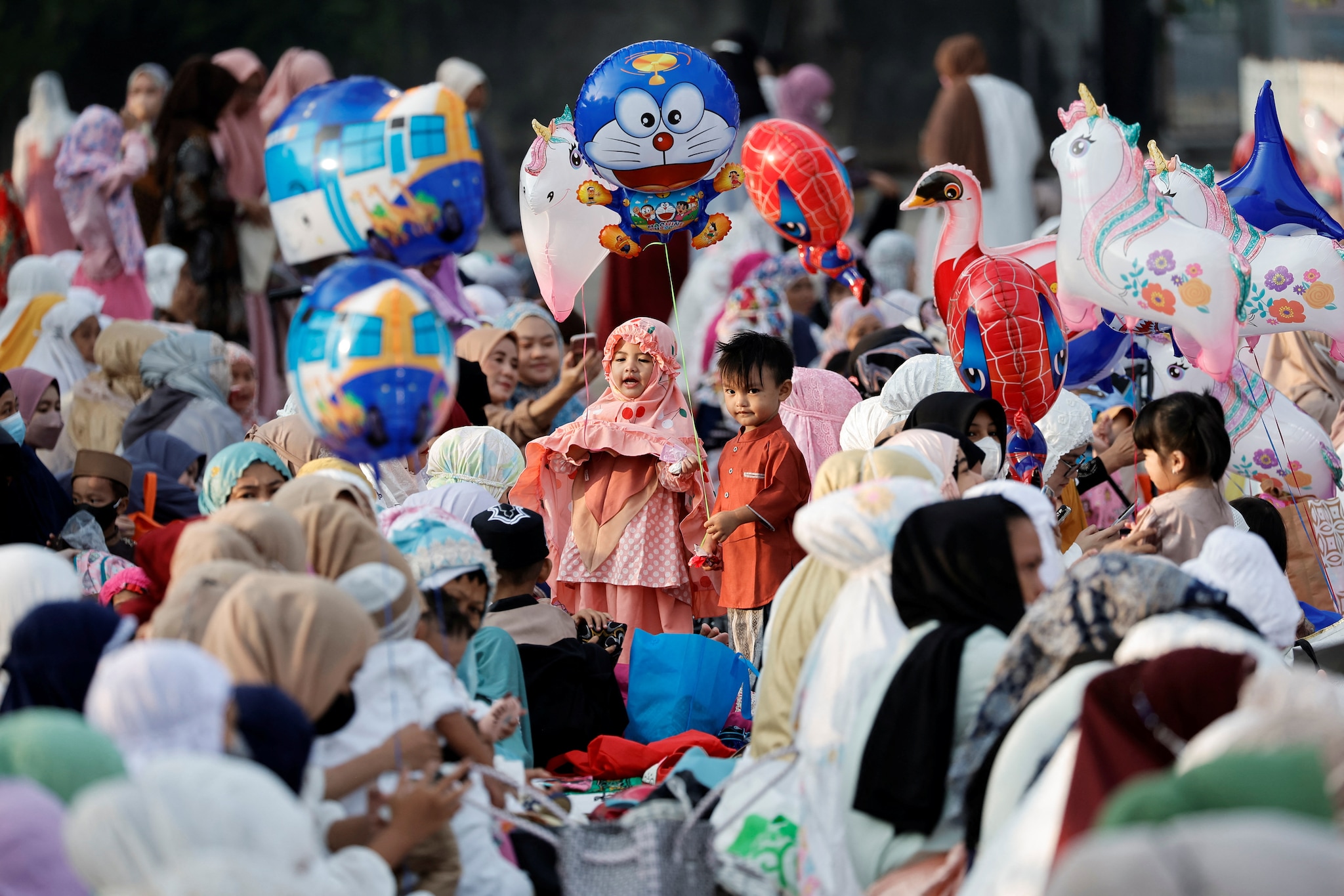 Muslim children hold balloons while attending mass prayers at the Sunda Kelapa port during Eid al-Fitr, marking the end of the holy fasting month of Ramadan, in Jakarta, Indonesia, on Monday. (Image: Reuters)