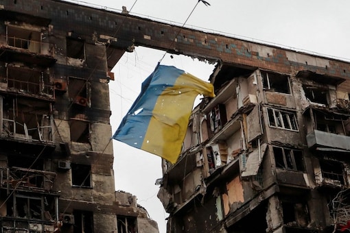 FILE PHOTO: A view shows a torn flag of Ukraine hung on a wire in front an apartment building destroyed during Ukraine-Russia conflict in the southern port city of Mariupol, Ukraine April 14, 2022. REUTERS