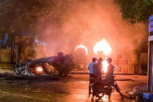 A vehicle belonging to the security personnel and a bus set alight is pictured near Sri Lanka's outgoing Prime Minister Mahinda Rajapaksa's official residence in Colombo May 9, 2022. (Image: AFP)