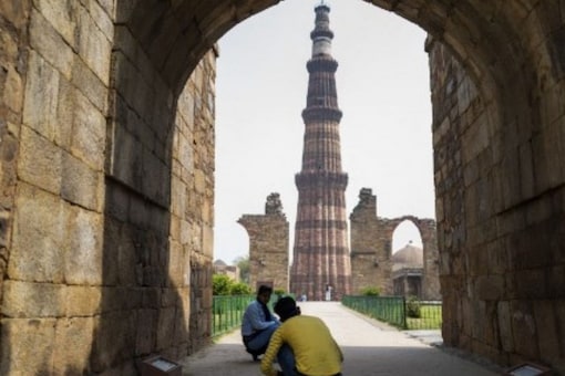 A tourist takes photos at the Qutub Minar archaeological complex in New Delhi. (Image: Jewel SAMAD/AFP)