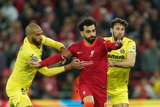 Liverpool's Mohamed Salah, center, fights for the ball with Villarreal's Etienne Capoue, left, Villarreal's Alfonso Pedraza during the Champions League semi final, first leg match between Liverpool and Villarreal at Anfield stadium in Liverpool, England, Wednesday, April 27, 2022. (AP Photo/Jon Super)
