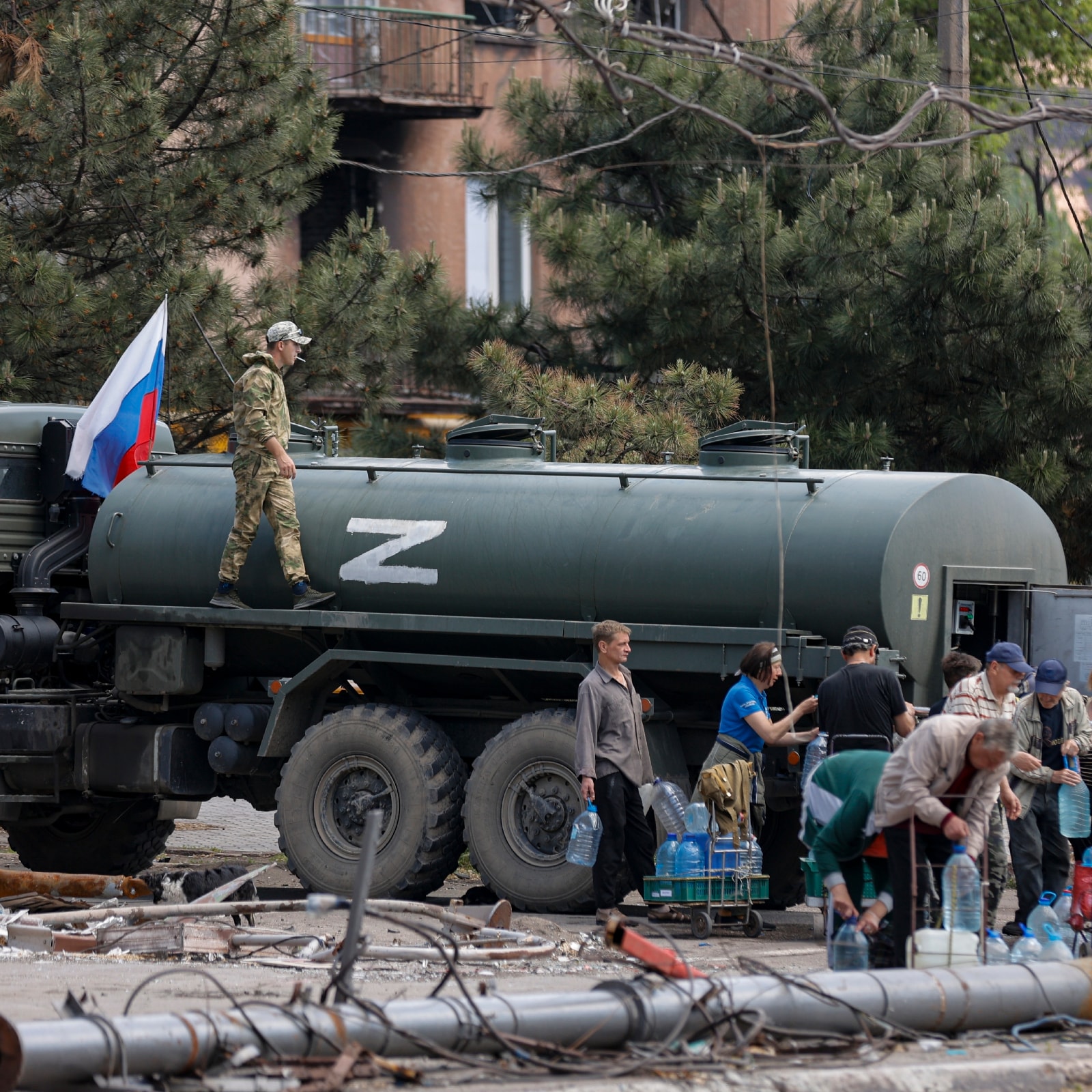 Local civilians gather to receive pure water distributed by Russian Emergency Situations Ministry in Mariupol, in territory under the government of the Donetsk People's Republic, eastern Ukraine with the letter Z, which has become a symbol of the Russian military on a board of the truck. (Image and Caption: AP Photo/Alexei Alexandrov)