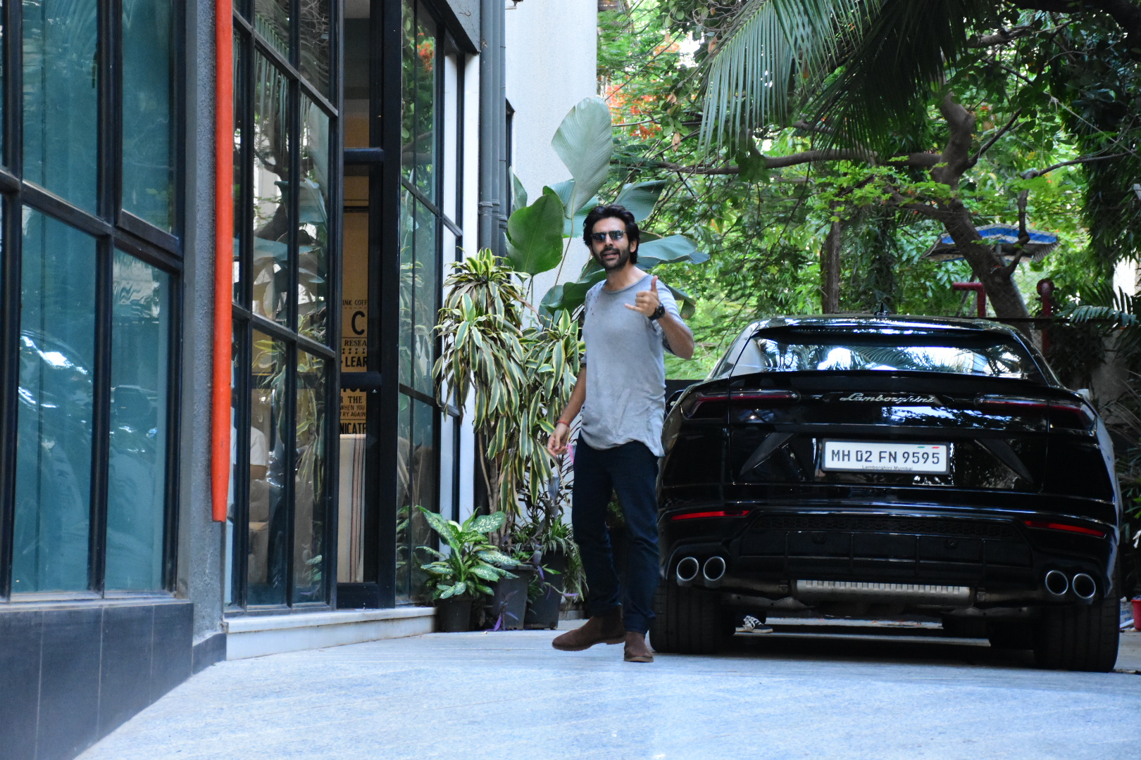 Kartik Aryan gestures to the media upon arrival for a meeting.