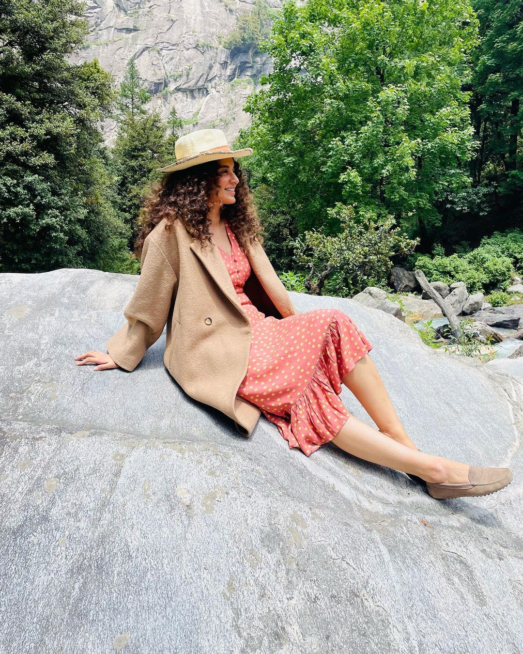 Kangana Ranaut strikes a pose as she sits atop a stone.