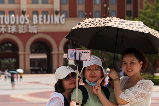 China in a shift to its Covid Zero policy has cut down quarantine time for travelers to 10 days. In this photo, tourists take selfies in front of the Universal Studios theme park as it reopens to the general public in Beijing. (Image: Reuters)