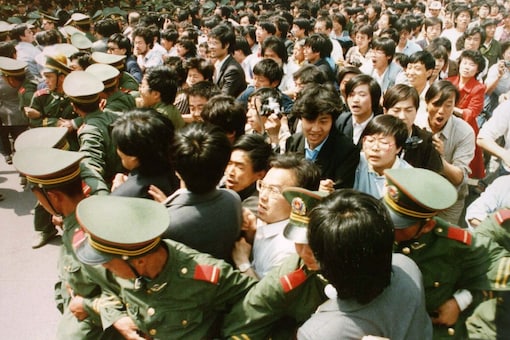 Crowds of jubilant students surge through a police cordon before pouring into Tiananmen Square on June 4, 1989. (Reuters)