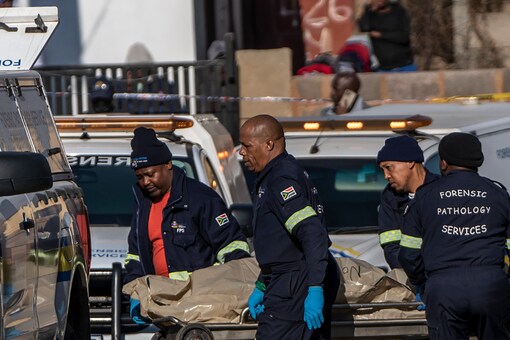 A body is removed from the scene of an overnight bar shooting in Soweto, South Africa. A mass shooting at a tavern in Johannesburg's Soweto township has killed 15 people and left others in critical condition. (Image: AP Photo/Shiraaz Mohamed)