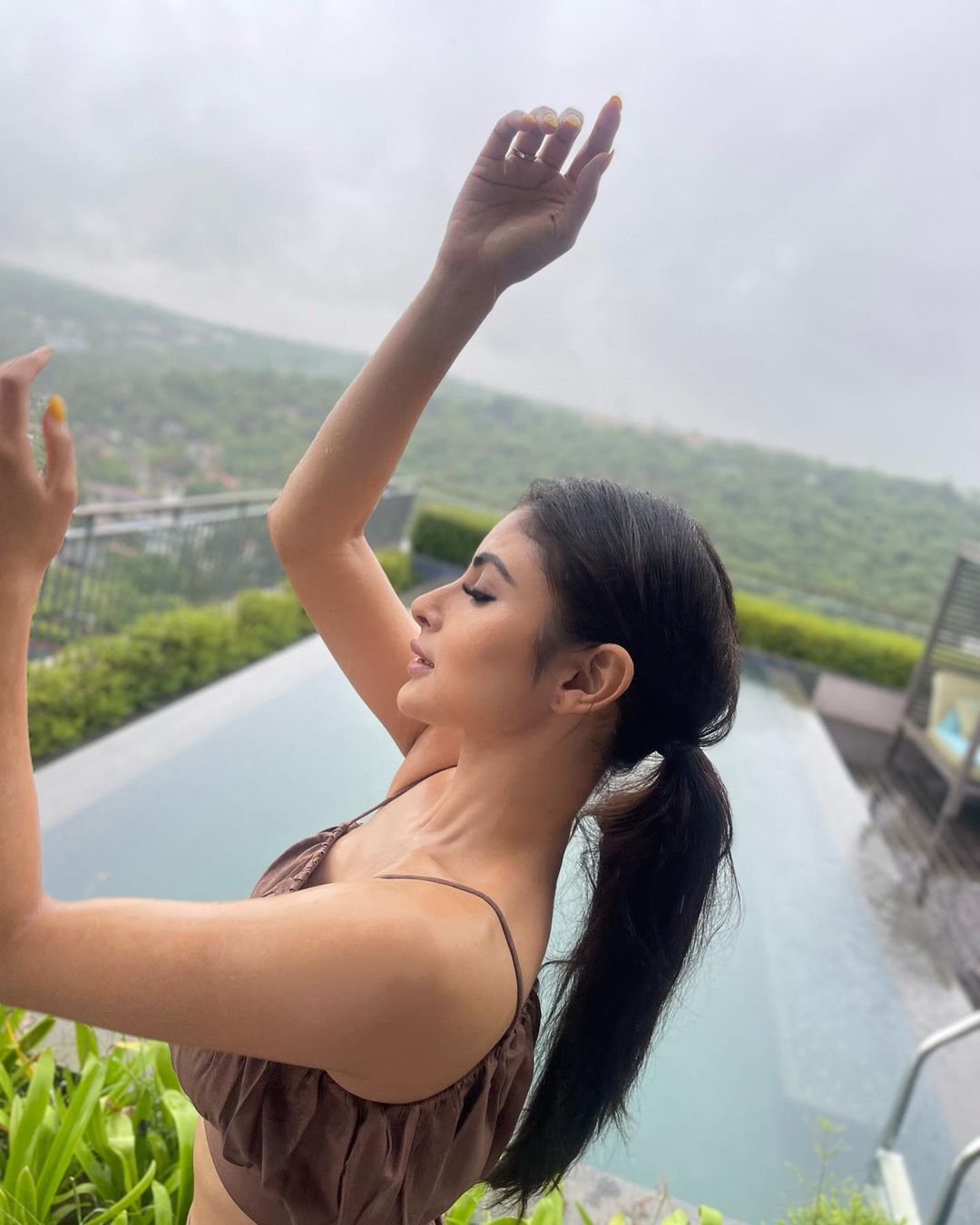 Mouni Roy keeps her hair tied into a messy ponytail.