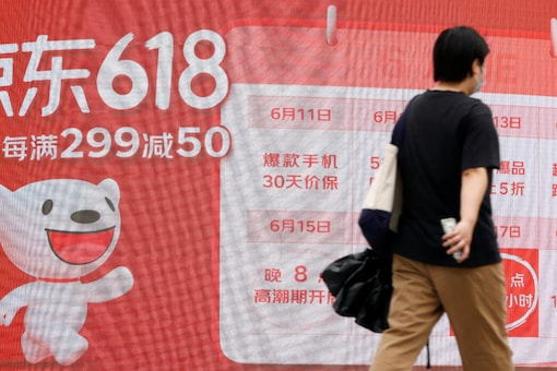 A resident walks past a JD.com advertisement for the 618 shopping festival displayed outside a shopping mall in Beijing, China (Image: Reuters)